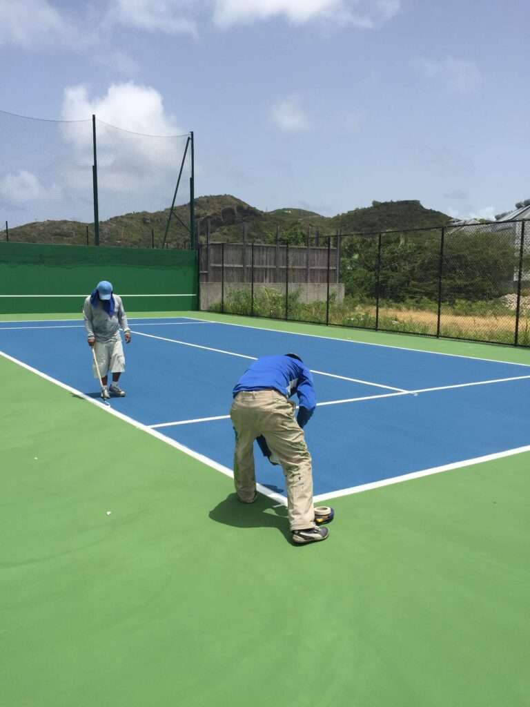 T3 Global Projects installation team working on a tennis court, showcasing the tennis court construction process.